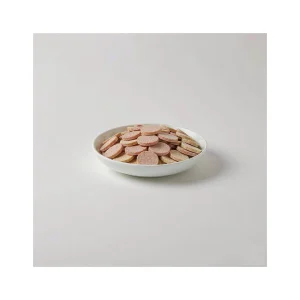 Freeze-dried raw pet food medallions in a white ceramic bowl